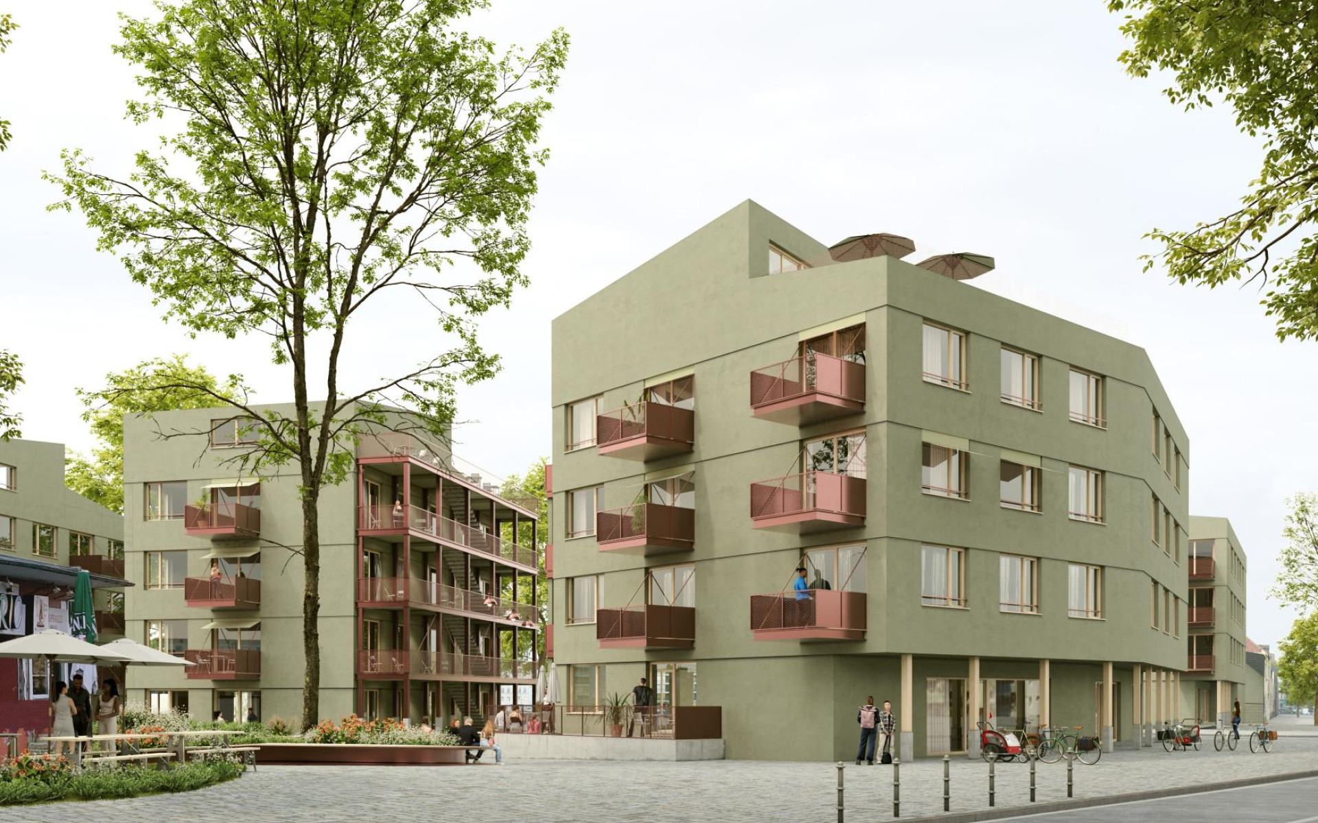 Moderne Wohnanlage mit flachen, grünen Gebäuden und Balkonen in urbanem Umfeld.